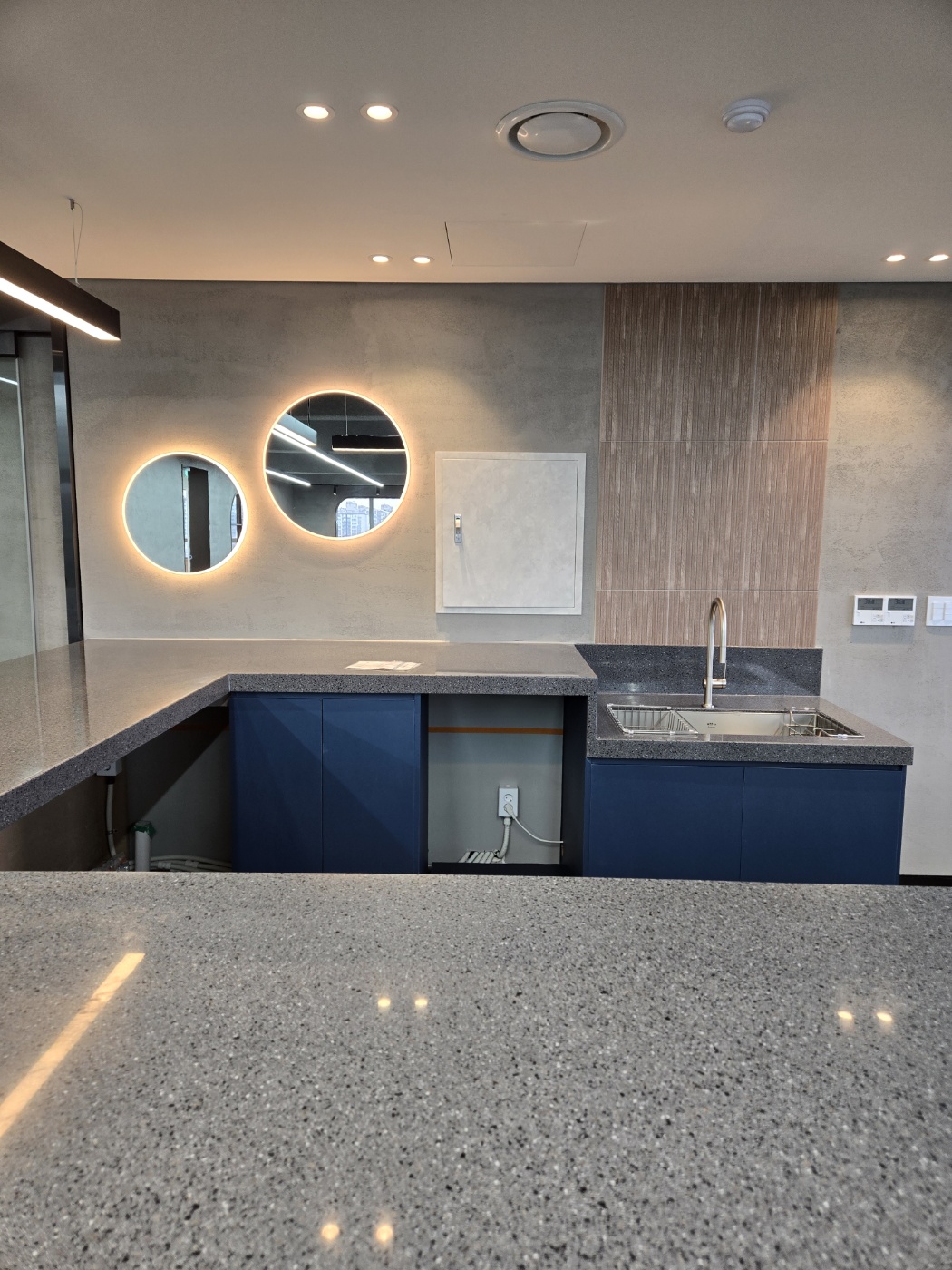 카운터 내부 - 원형 간접조명과 오이코스 벽면 마감